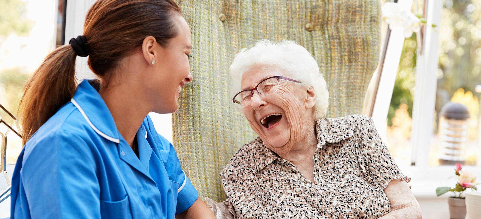Home Caregiver and Client Laughing